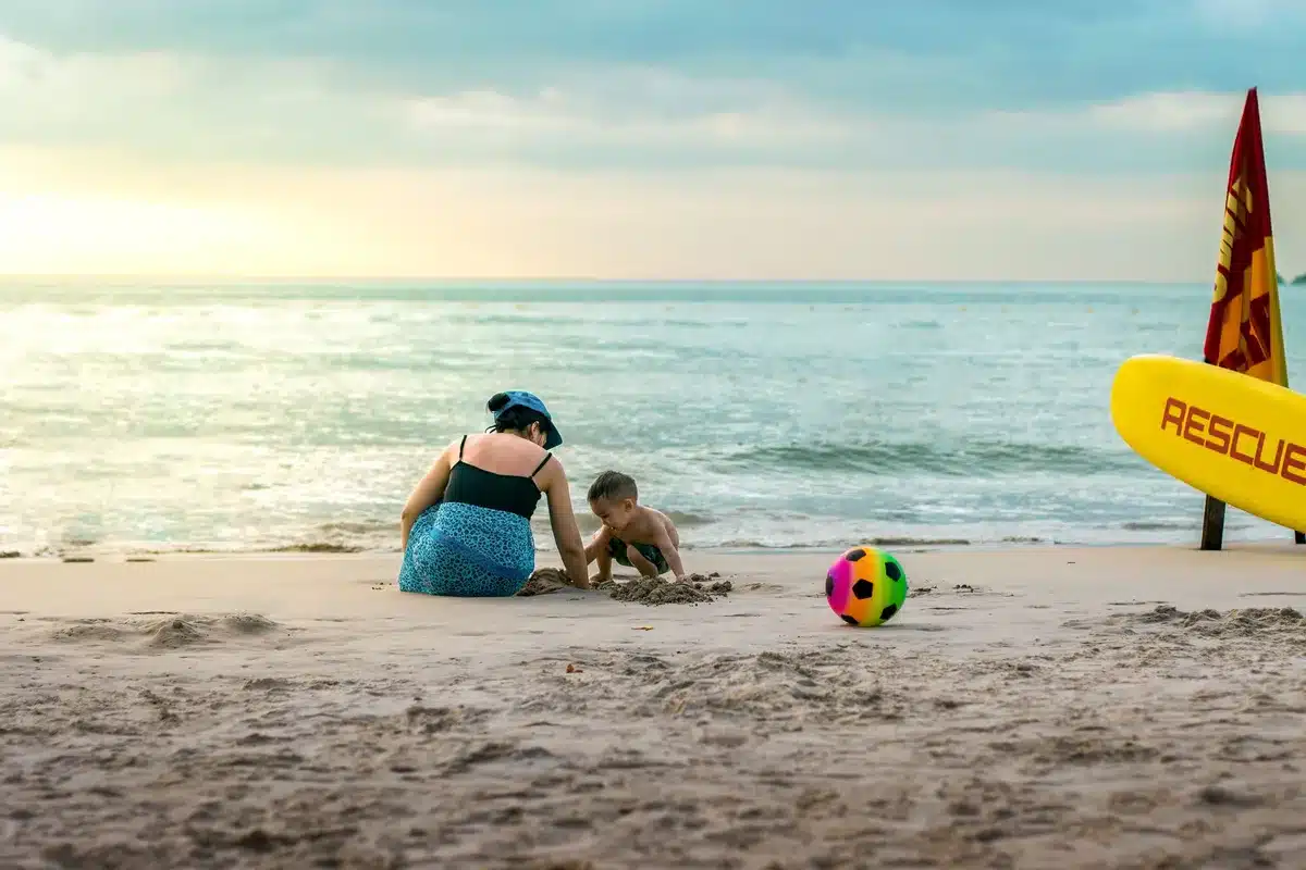 Persona limpiando una herida en la playa antes de entrar al agua marina