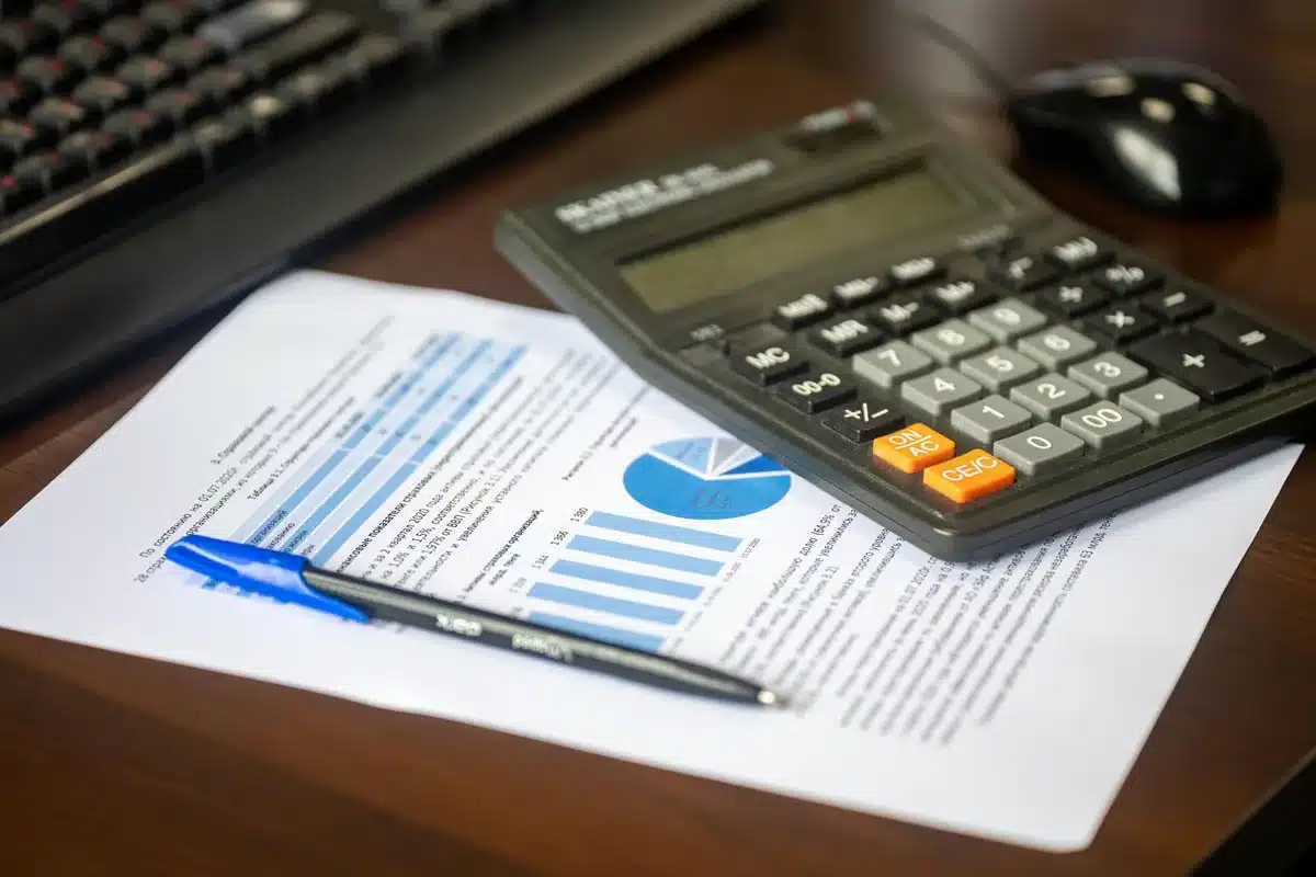 Documentos de presupuesto e inversión municipal sobre escritorio con calculadora