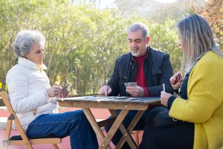 Documentos de pensión y tarjeta de salud sobre una mesa, con gafas de lectura
