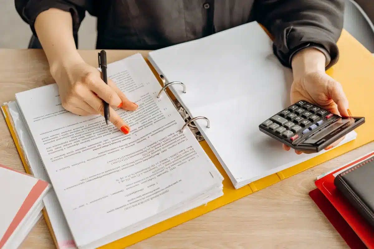 Documentos de divorcio y calculadora sobre escritorio para ilustrar costos