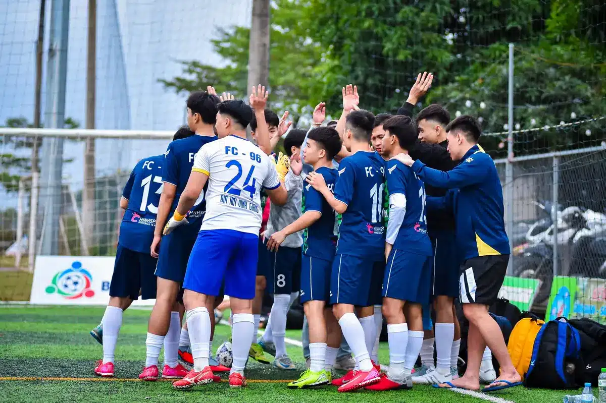 Entrenador y jugadores analizando estrategia táctica antes de un partido crucial