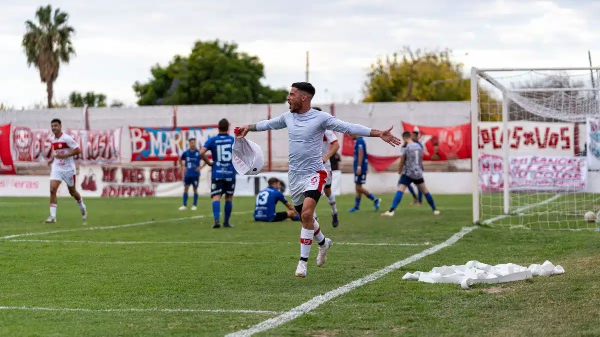 Delantero celebrando un gol con los brazos levantados en el estadio