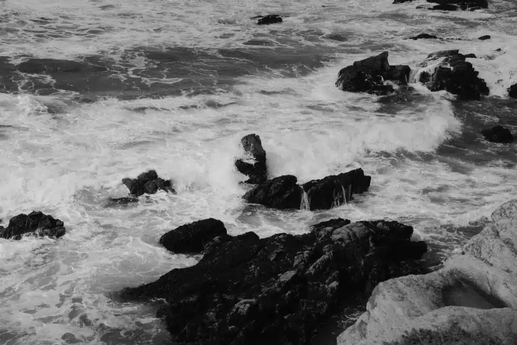 Olas tormentosas golpeando la costa con cielo oscuro y lluvia inminente