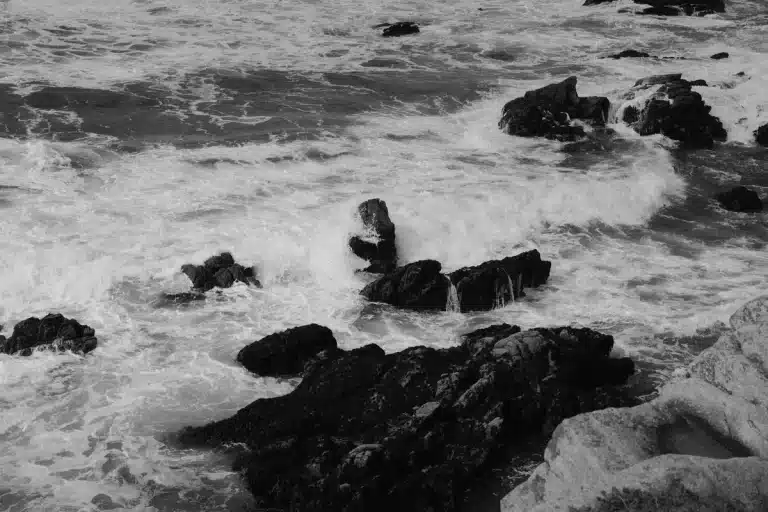 Olas tormentosas golpeando la costa con cielo oscuro y lluvia inminente