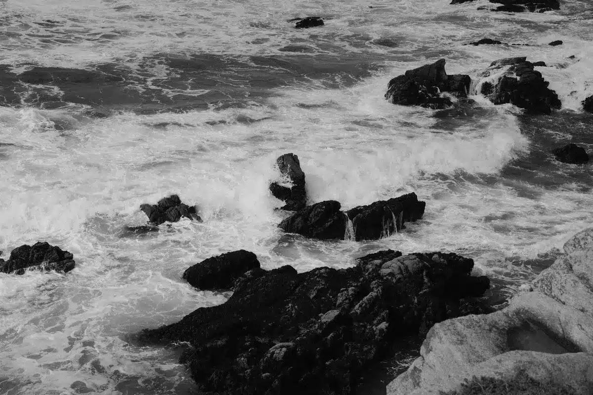Olas tormentosas golpeando la costa con cielo oscuro y lluvia inminente