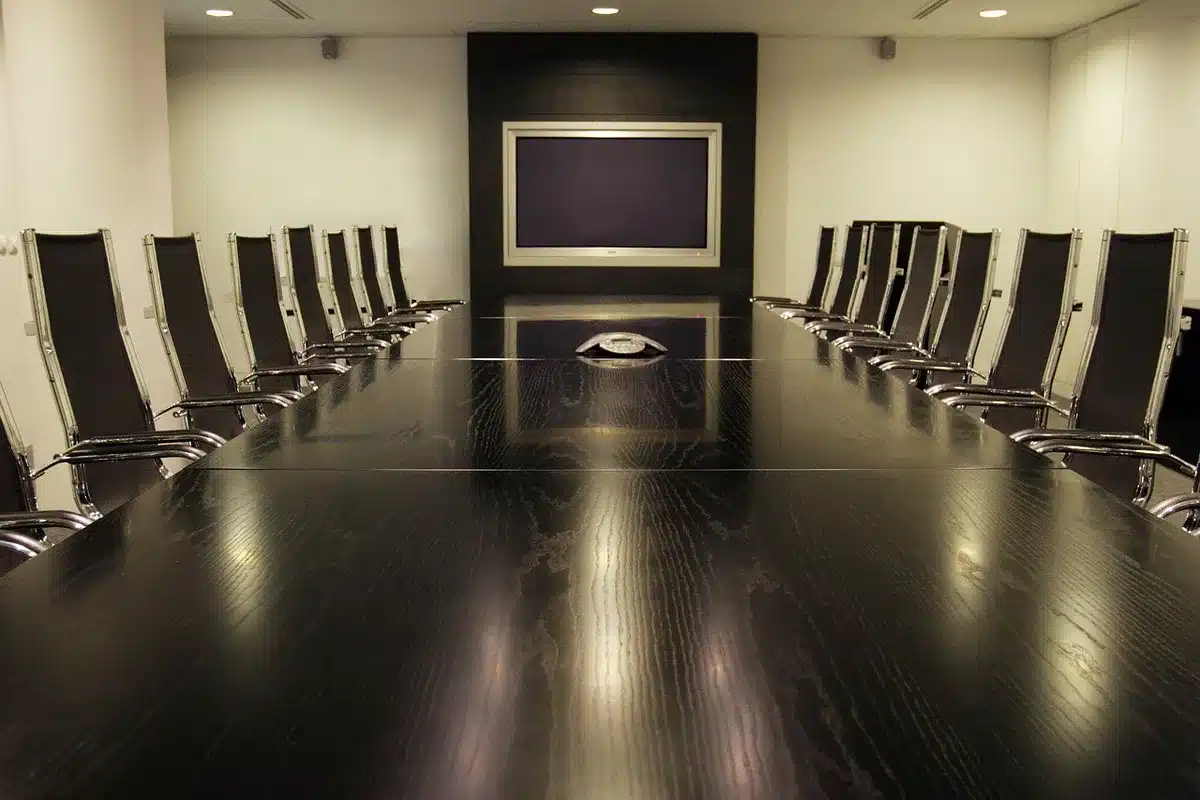 Sala de reuniones con documentos y micrófonos, simbolizando una junta del banco central